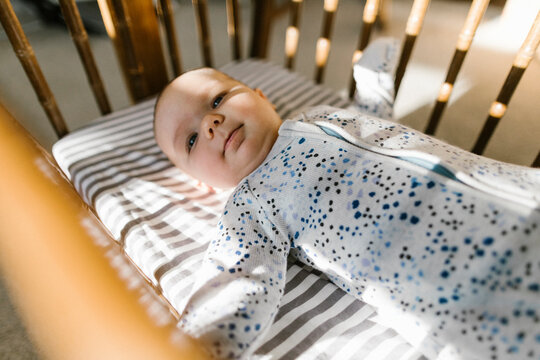 Side view of baby laying in crib.