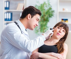 Fototapeta premium Doctor checking patients ear during medical examination