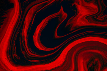 Fluid art texture. Background with abstract iridescent paint effect. Liquid acrylic picture that flows and splashes. Mixed paints for posters or wallpapers. Orange, red and black overflowing colors