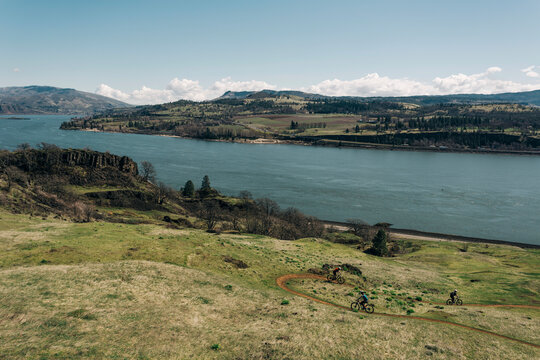 A group of girls bike along a trail overlooking the Columbia River.