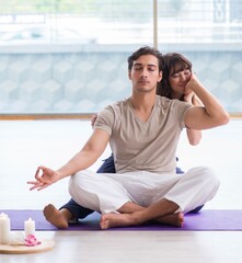 Personal coach helping during yoga session