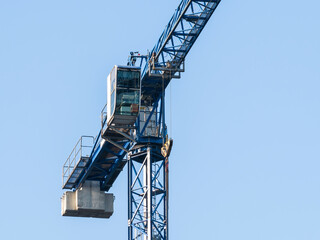Fototapeta na wymiar Close up details with a cabin control of a construction crane.Turret Slewing Crane against blue sky