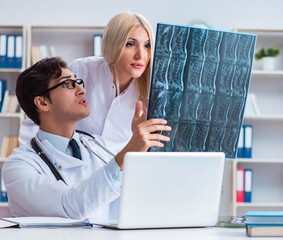 Two doctors examining x-ray images of patient for diagnosis