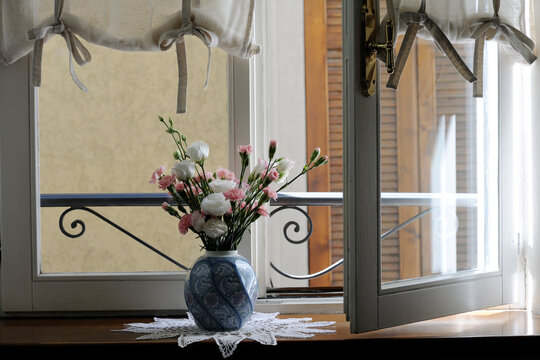 Flower vase on table by window at home