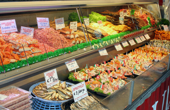 Belgium - Ostend - The stall with fresh and smoked seafood like fish, herring, lobsters, shrimps, sprats, urchins as well as mixture salads of them in local fish market on north sea coast