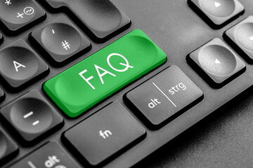 grüne "FAQ" Taste auf einer dunklen Tastatur