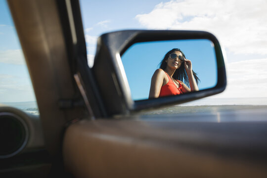 Mixed race woman on sunny day reflecting in a mirror