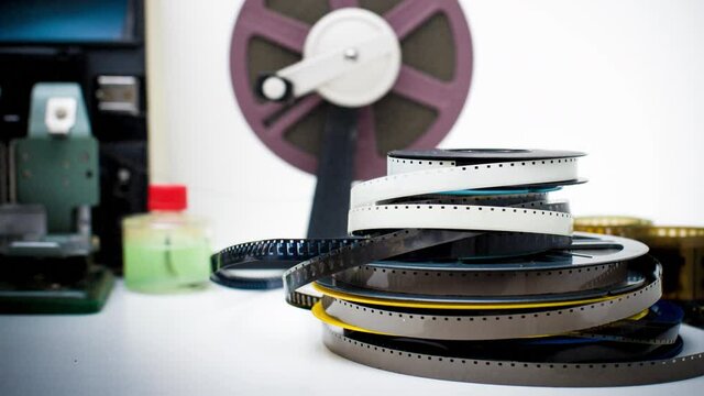 Movie film cinema background, editing table with heap of 8mm reels