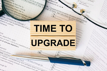 Wooden blocks with text Time To Upgrade on financial docs