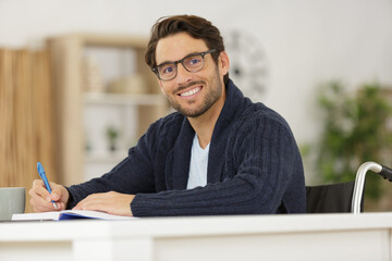 Naklejka premium disabled young man studying at home