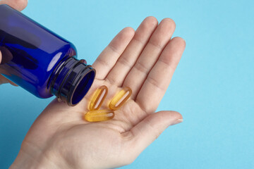 Orange tablets spilling out of package on a hand. Heap of pills - medical background