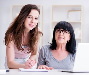 Daughter explaining to mom how to use computer