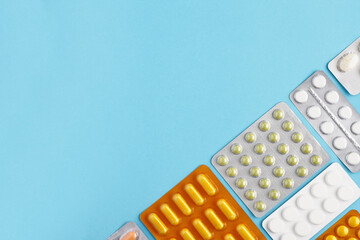 Top view of blisters pack of medicine pills on a blue background. Heap of pills - medical background