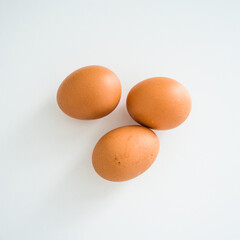 Close up of fresh raw brown chicken eggs on white table. Ingridients for healthy food. Top view.