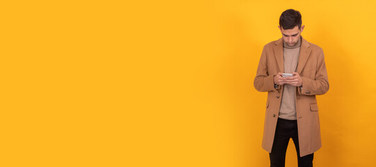 young man with mobile phone on color background