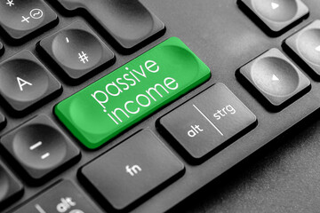 grüne "passive income" Taste auf einer dunklen Tastatur