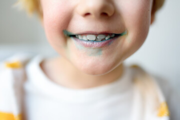 Little boy is learning carefully brush teeth. Child using liquid for disclosing plaque. Teaching...