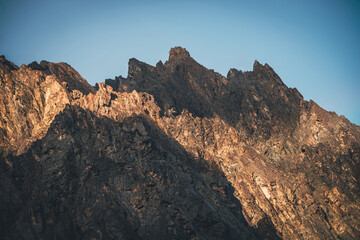 Scenic mountain landscape with great rocks in golden sunlight. Awesome rocky wall with sharp top in...