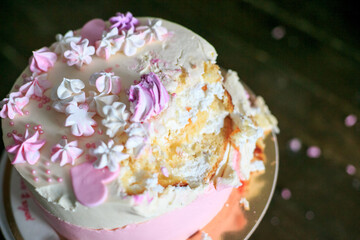 copy space one year old cake smash. 1 year old birthday with pink macaroni destroyed bitten on wodden background. Celebration concept. Top view. Close up ruined pink cake. Baking for holiday. goodies