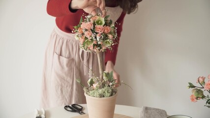 Mujer tocando arreglo de rosas rosadas