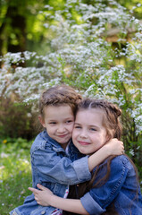 Fototapeta premium Two adorable little girls hugging each other in the a spring park.