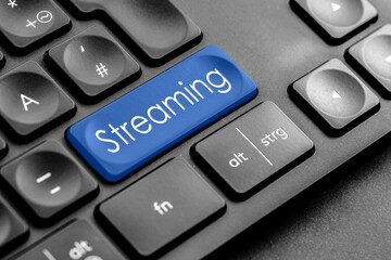 blaue "Streaming" Taste auf einer dunklen Tastatur	
