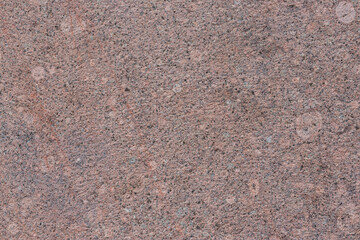 Granite texture. Natural pink granite with a grainy pattern. Stone background. Solid rough surface of rock. Durable construction and decoration material. Close-up.