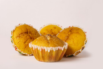 Four cupcakes on a plate on a white background