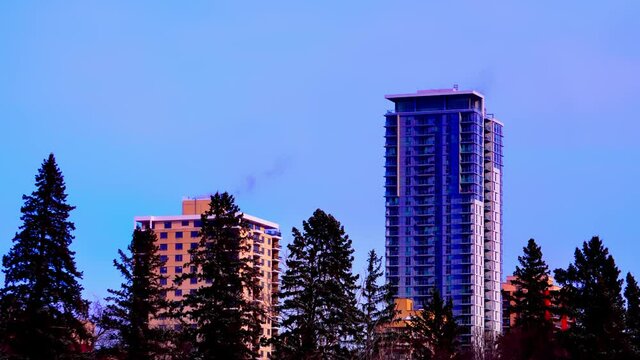 Hilltop and the Saskatchewan condominium behind tall pine trees time lapse next to the Hendrix Rental Apartment from the lower Victoria Park view time lapse winter weather twilight sunset navy blue