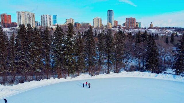 Extreme Winter Cold in Victoria Park Skating Rink double some people skating at minus 30 to 40 celsius afternoon with a background horizon overlooking Hendrix Legislature Crestview Tower Condos EDM1-4