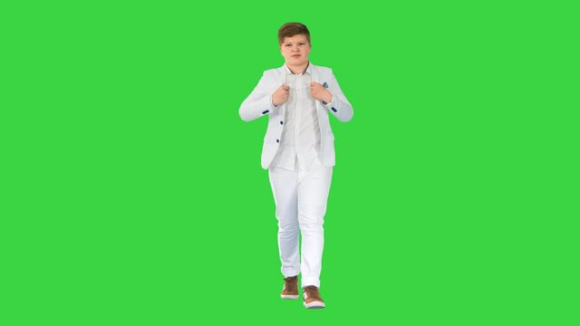 Successful business teen in white suit walking on a Green Screen, Chroma Key.