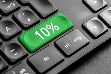 grüne 10% Taste auf einer dunklen Tastatur