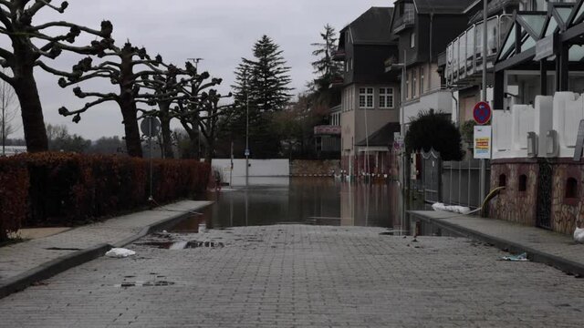 Kid Walks In The Flooded Walkway In The Town Of Walluf In Germany. wide shot