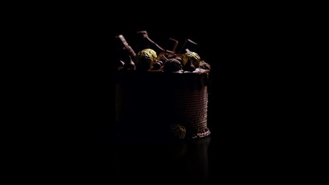 Light hovers over a huge chocolate cake creating a silhouette as it passes over and to the back of the cake.