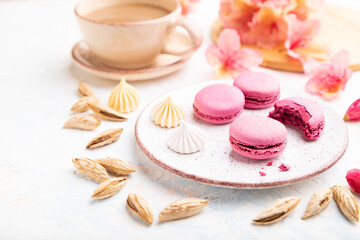 Purple macarons or macaroons cakes with cup of coffee on a white concrete background. Side view, close up, selective focus.