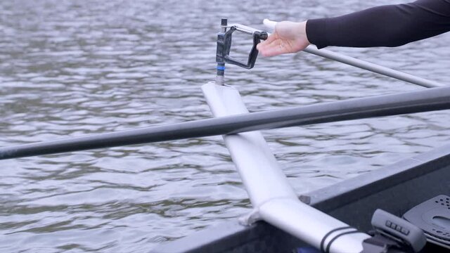 Close up clip of a rower unscrewing and attaching their oar to a rigger, outfoors while floating on the Utrecht canal in the Netherlands