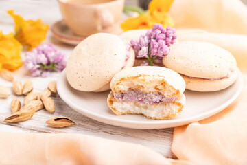Meringues cakes with cup of coffee on a white wooden background. Side view, selective focus.