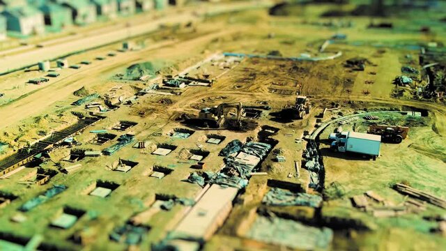 Large construction site with heavy equipment and people at work - aerial time lapse tilt shift effect