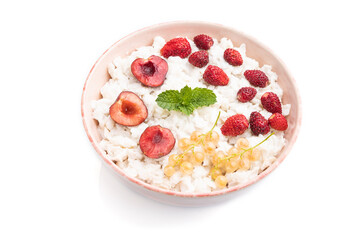 Rice flakes porridge with milk and strawberry in ceramic bowl isolated on white background. Side view.