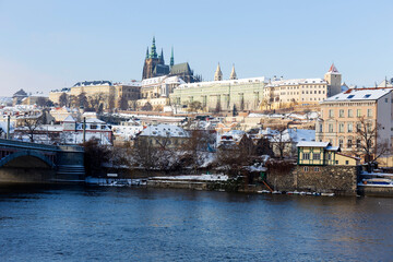 Obraz premium Snowy Prague Lesser Town with Prague Castle above River Vltava in the sunny Day , Czech republic
