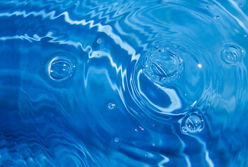 Blue swimming pool water background with drops and bubbles.