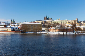 Obraz premium Snowy Prague Lesser Town with Prague Castle above River Vltava in the sunny Day , Czech republic