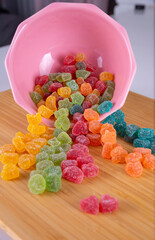 Multi-coloured candies, Multi-coloured candies in a pink bowl and wooden background