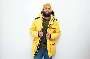 Portrait of a handsome man with beard in a yellow winter jacket isolated background