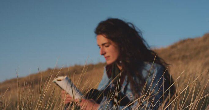 Attractive woman reading a book at the beach