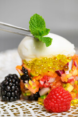 Close up view of fine cuisine chef placing mint leave on the top of served dish with kitchen tweezers while decorating it. High quality photo.
