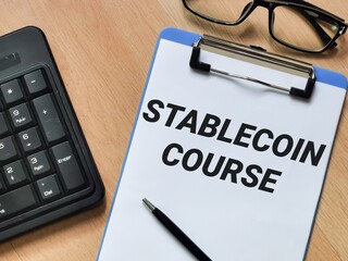 Business and technology concept. Phrase STABLECOIN COURSE written on paper clipboard with pen,keyboard and eye glasses. 