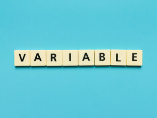 VARIABLE word made from square letter tiles on blue background.