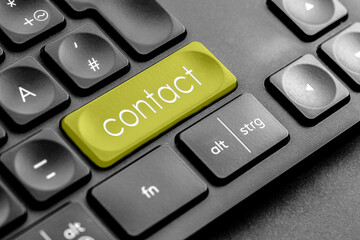 gelbe contact Taste auf einer dunklen Tastatur