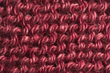 Closeup of burgundy colored knitted yarn pattern